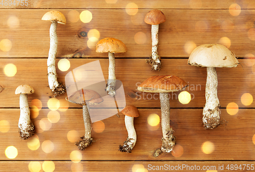 Image of brown cap boletus mushrooms on wooden background