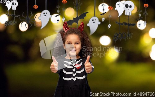 Image of girl in black dress and devil's horns on halloween