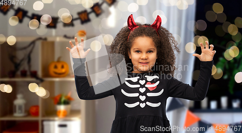 Image of girl in black dress and devil's horns on halloween