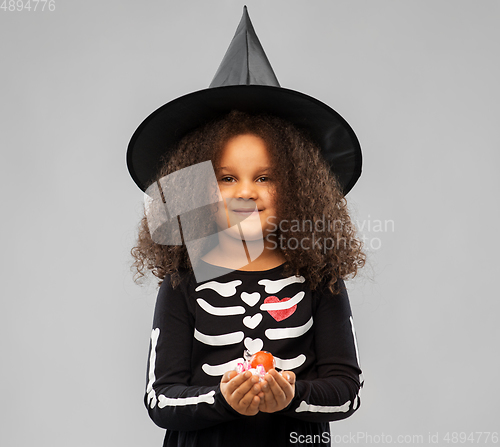 Image of girl with candies trick-or-treating on halloween