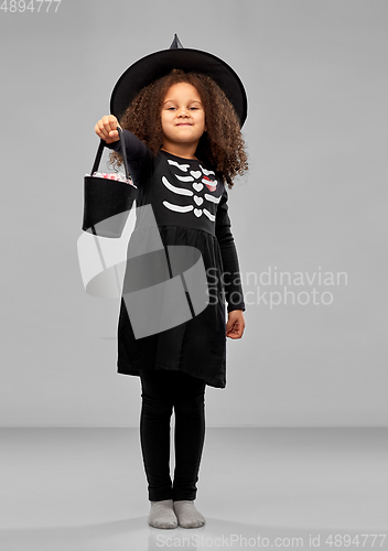 Image of girl with candies trick-or-treating on halloween