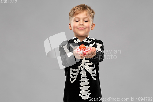 Image of boy with candies trick-or-treating on halloween