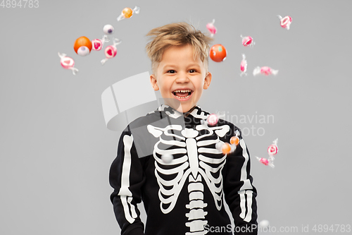 Image of boy with candies trick-or-treating on halloween