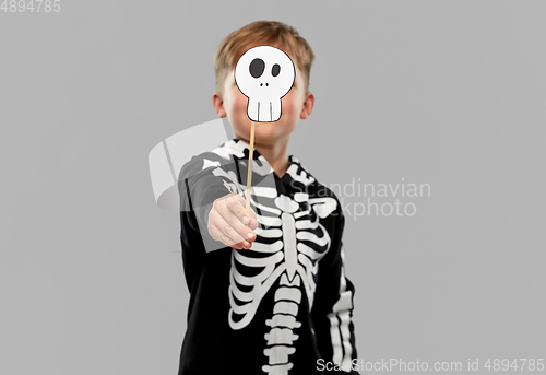 Image of boy in halloween costume with scull accessory