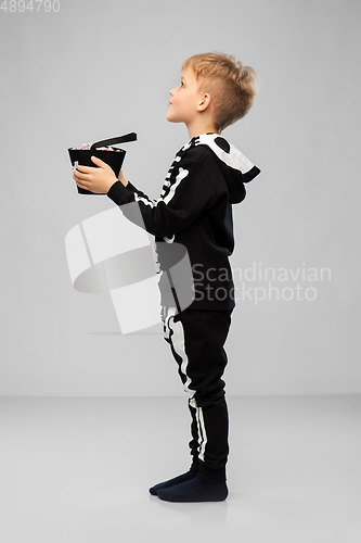 Image of boy with candies trick-or-treating on halloween