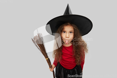 Image of girl in black witch hat with broom on halloween