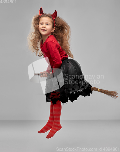 Image of girl in halloween costume flying with witch broom