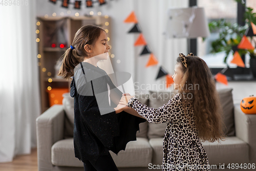 Image of girls in halloween costumes dancing at home