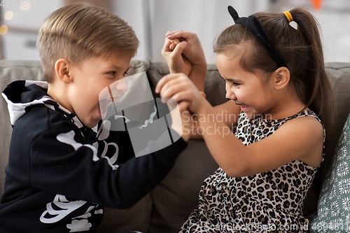 Image of kids in halloween costumes having fun at home