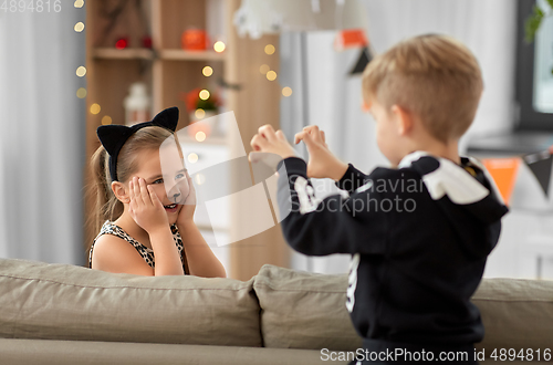 Image of kids in halloween costumes playing at home