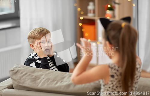 Image of kids in halloween costumes playing at home