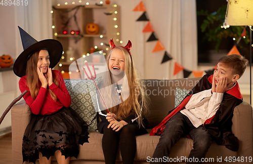 Image of kids in halloween costumes playing at home