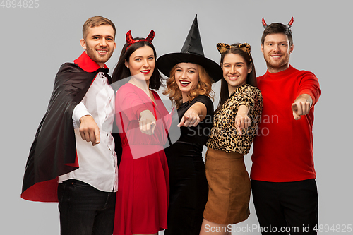 Image of happy friends in halloween costumes over grey