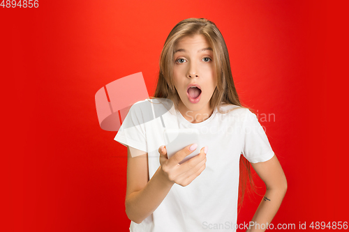 Image of Portrait of young caucasian woman with bright emotions on bright red studio background