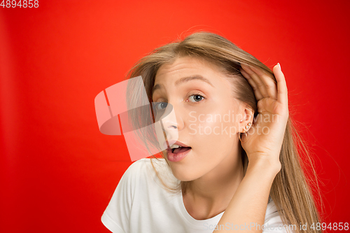 Image of Portrait of young caucasian woman with bright emotions on bright red studio background