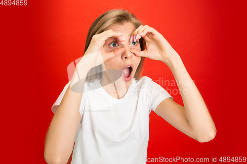 Image of Portrait of young caucasian woman with bright emotions on bright red studio background