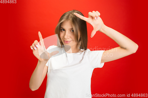 Image of Portrait of young caucasian woman with bright emotions on bright red studio background