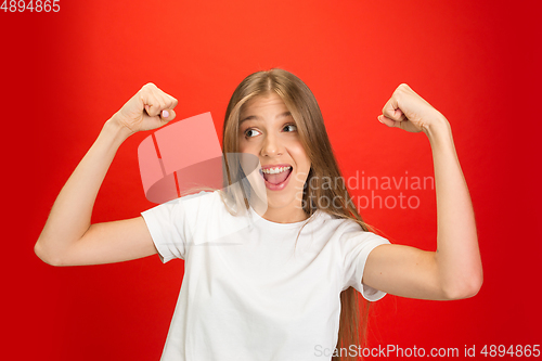 Image of Portrait of young caucasian woman with bright emotions on bright red studio background