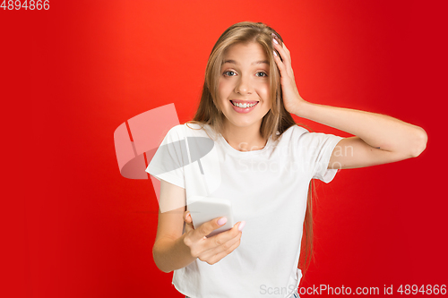 Image of Portrait of young caucasian woman with bright emotions on bright red studio background