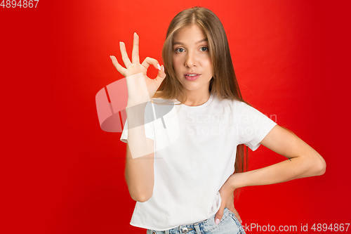 Image of Portrait of young caucasian woman with bright emotions on bright red studio background