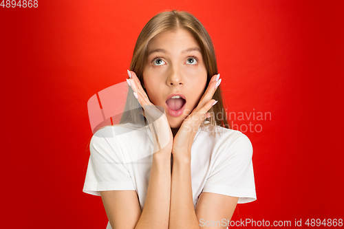 Image of Portrait of young caucasian woman with bright emotions on bright red studio background
