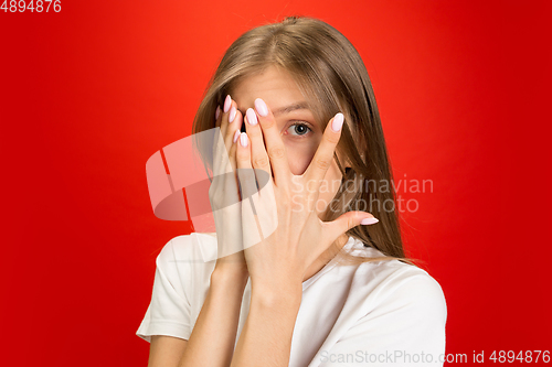 Image of Portrait of young caucasian woman with bright emotions on bright red studio background