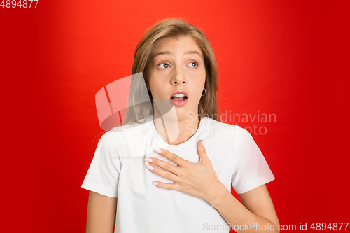 Image of Portrait of young caucasian woman with bright emotions on bright red studio background