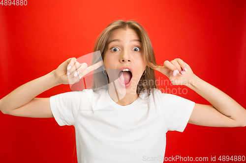 Image of Portrait of young caucasian woman with bright emotions on bright red studio background