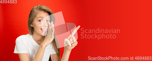 Image of Portrait of young caucasian woman with bright emotions on bright red studio background