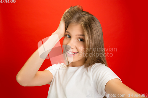 Image of Portrait of young caucasian woman with bright emotions on bright red studio background