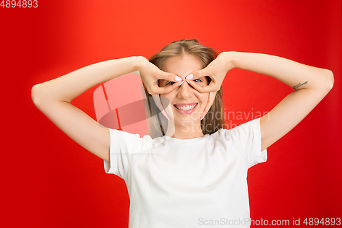 Image of Portrait of young caucasian woman with bright emotions on bright red studio background