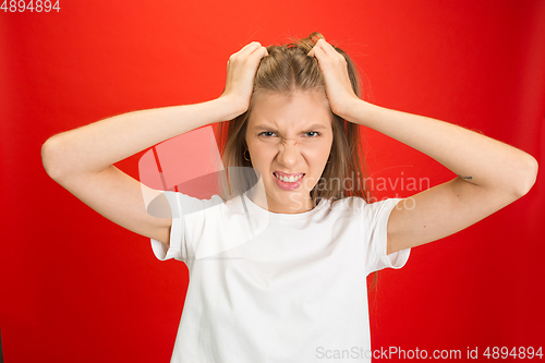 Image of Portrait of young caucasian woman with bright emotions on bright red studio background