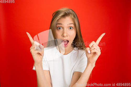 Image of Portrait of young caucasian woman with bright emotions on bright red studio background