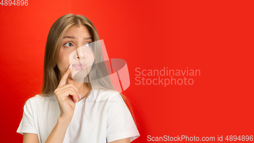 Image of Portrait of young caucasian woman with bright emotions on bright red studio background