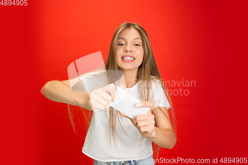 Image of Portrait of young caucasian woman with bright emotions on bright red studio background