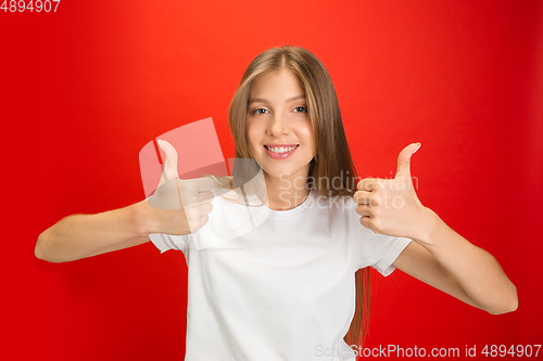 Image of Portrait of young caucasian woman with bright emotions on bright red studio background