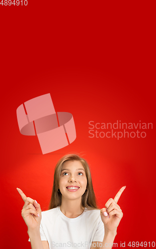 Image of Portrait of young caucasian woman with bright emotions on bright red studio background