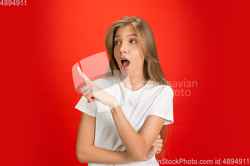 Image of Portrait of young caucasian woman with bright emotions on bright red studio background