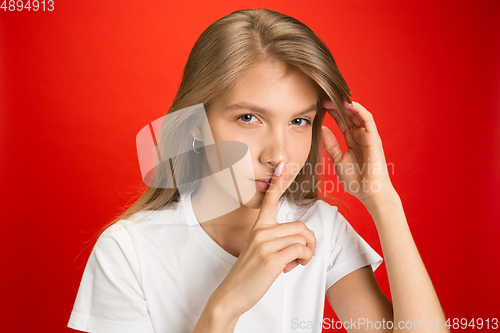 Image of Portrait of young caucasian woman with bright emotions on bright red studio background