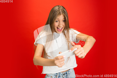 Image of Portrait of young caucasian woman with bright emotions on bright red studio background