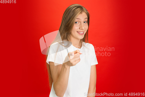 Image of Portrait of young caucasian woman with bright emotions on bright red studio background