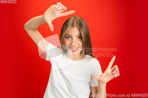 Image of Portrait of young caucasian woman with bright emotions on bright red studio background