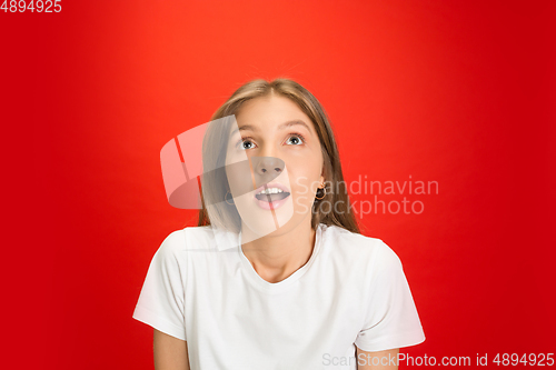 Image of Portrait of young caucasian woman with bright emotions on bright red studio background