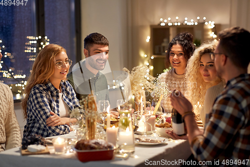 Image of happy friends with red wine at christmas party