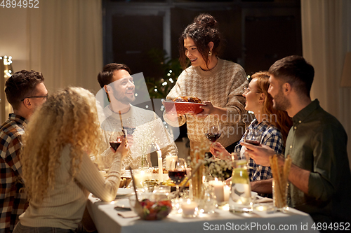 Image of happy friends having christmas dinner at home