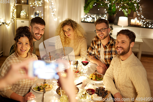 Image of friends photographing at christmas dinner party
