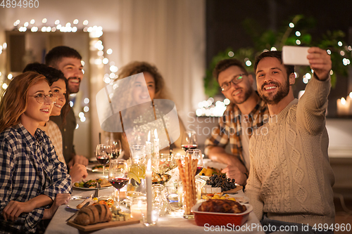 Image of friends taking selfie at christmas dinner party