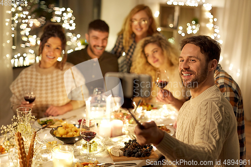 Image of friends taking selfie at christmas dinner party