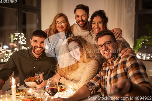 Image of friends taking selfie at christmas dinner party