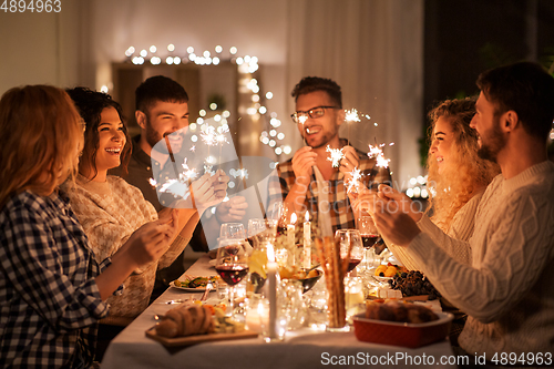 Image of happy friends having christmas dinner at home